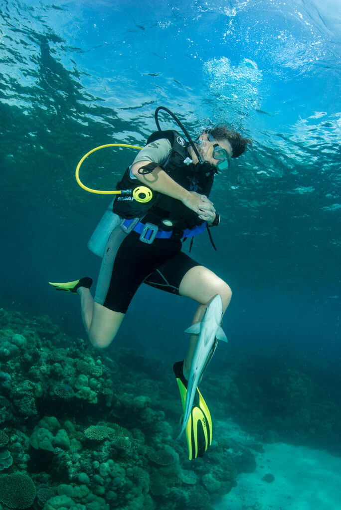 a-scuba-diver-with-a-fish-stuck-to-his-leg