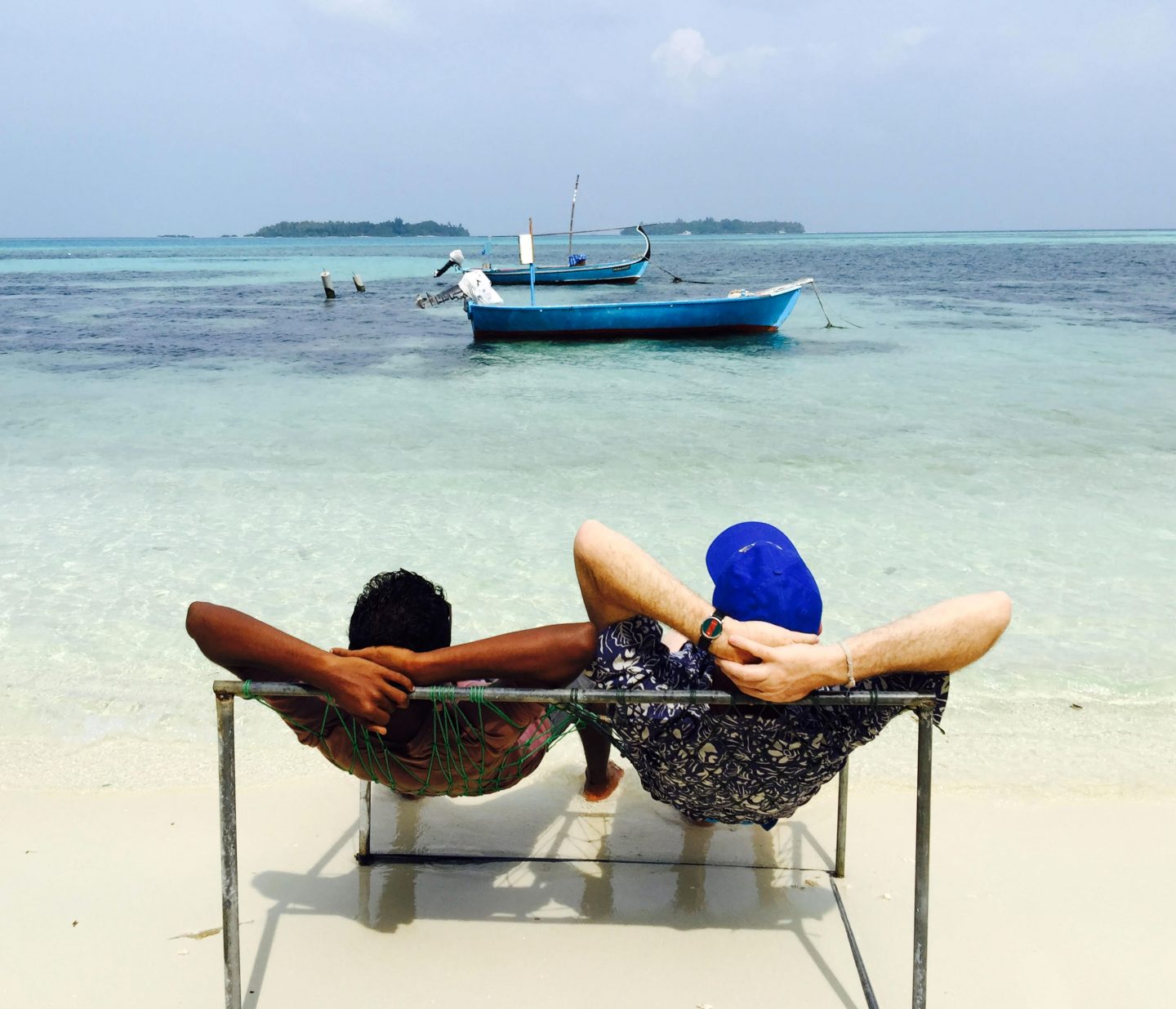 "A-guest-unwinding-at-a-Maldivian-beach-in-a-joali-accompanied-by-a-local-touch