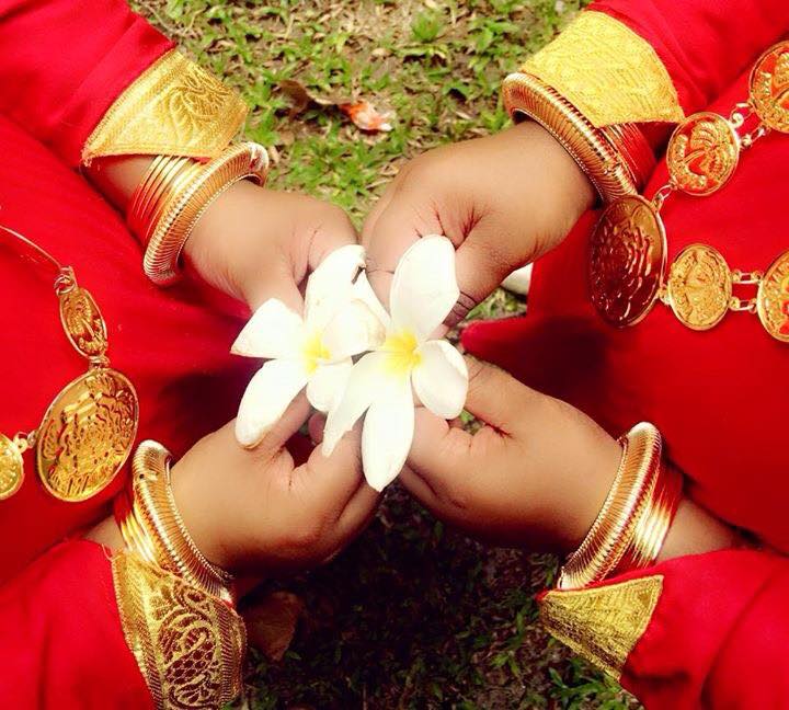 Two-ladies-dressed-in-tarditional-maldivian-dresses-holding-temple-flowers