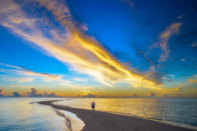 a-couple-standing-on-a-long-strech-of-beach