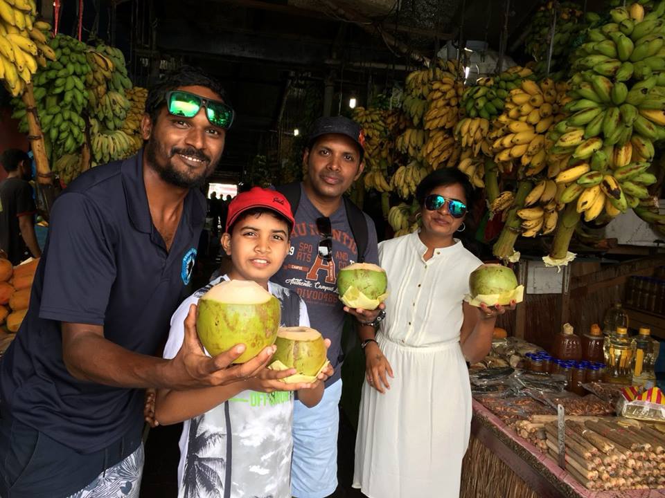 Secret-Paradise-Guide-with-a-familly-enjoy-a-coconut-the-traditional-way-without-the-aid-of-a-plastic-straw