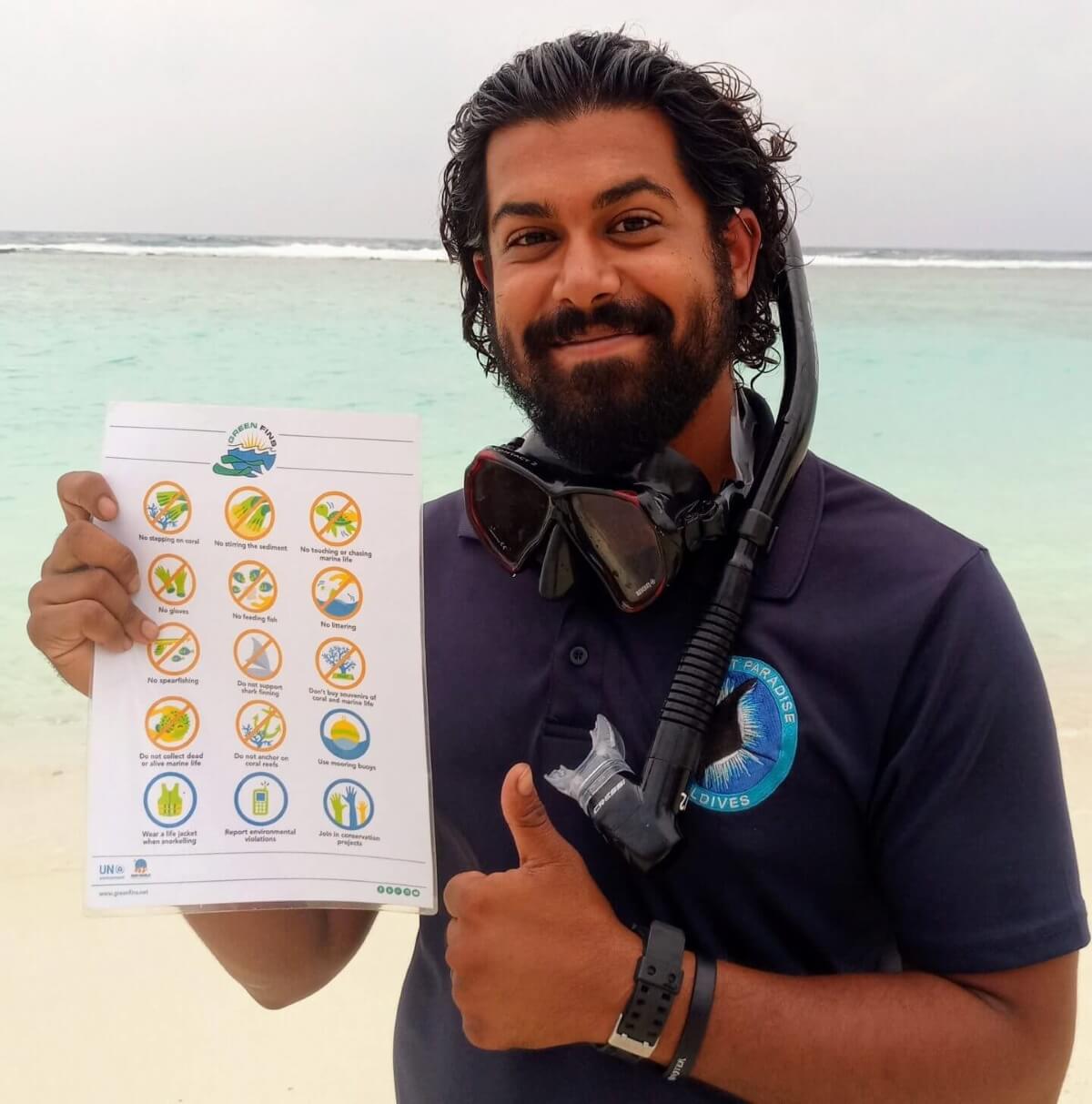 secret paradise staff member shows the list of things not to do in the ocean