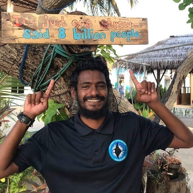 secret paradise staff member points to a wooden tab