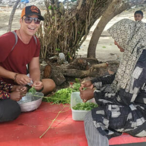 A man prepares vegetables with a cooking host